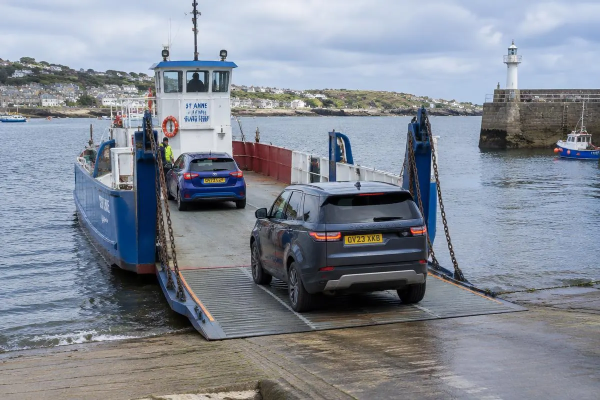 Cars driving up the loading ramp of a chain ferry at a slipway